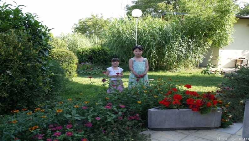 Катя и Лиза в садике перед домом