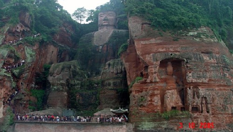 Вид с реки на статую Будды, вырубленную в скале близ города Лишань.