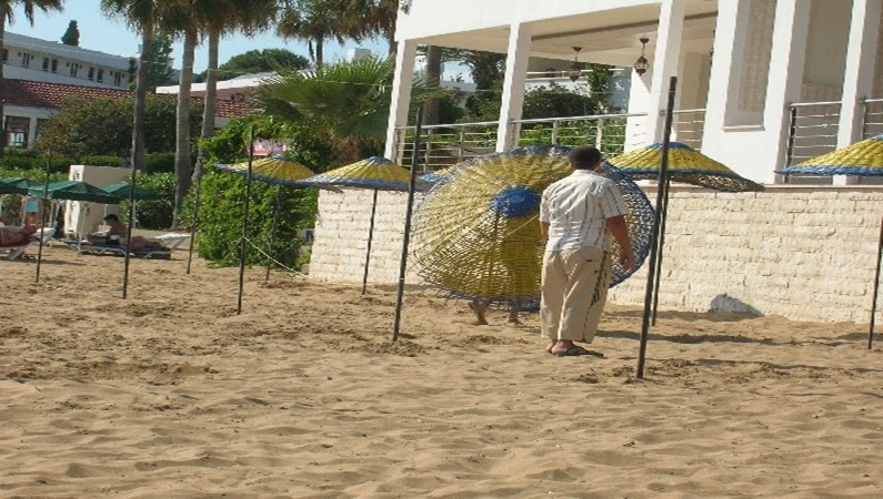 Пляж : монтаж зонтиков